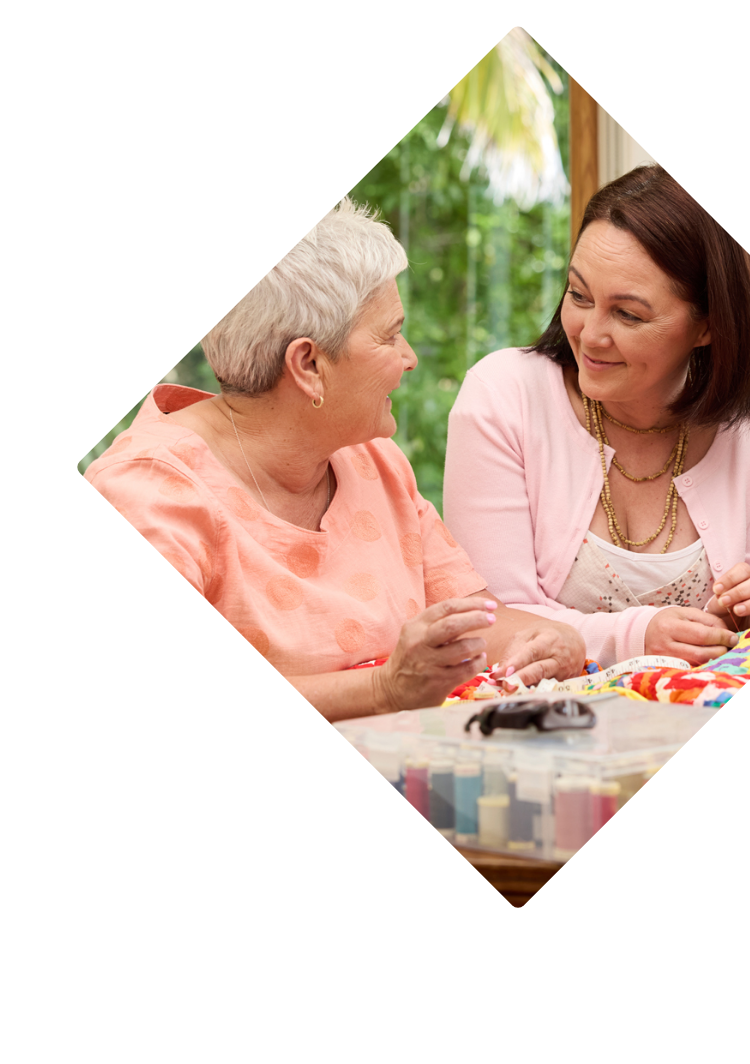 Two Wahine (women) talking whilst sewing a quilt
